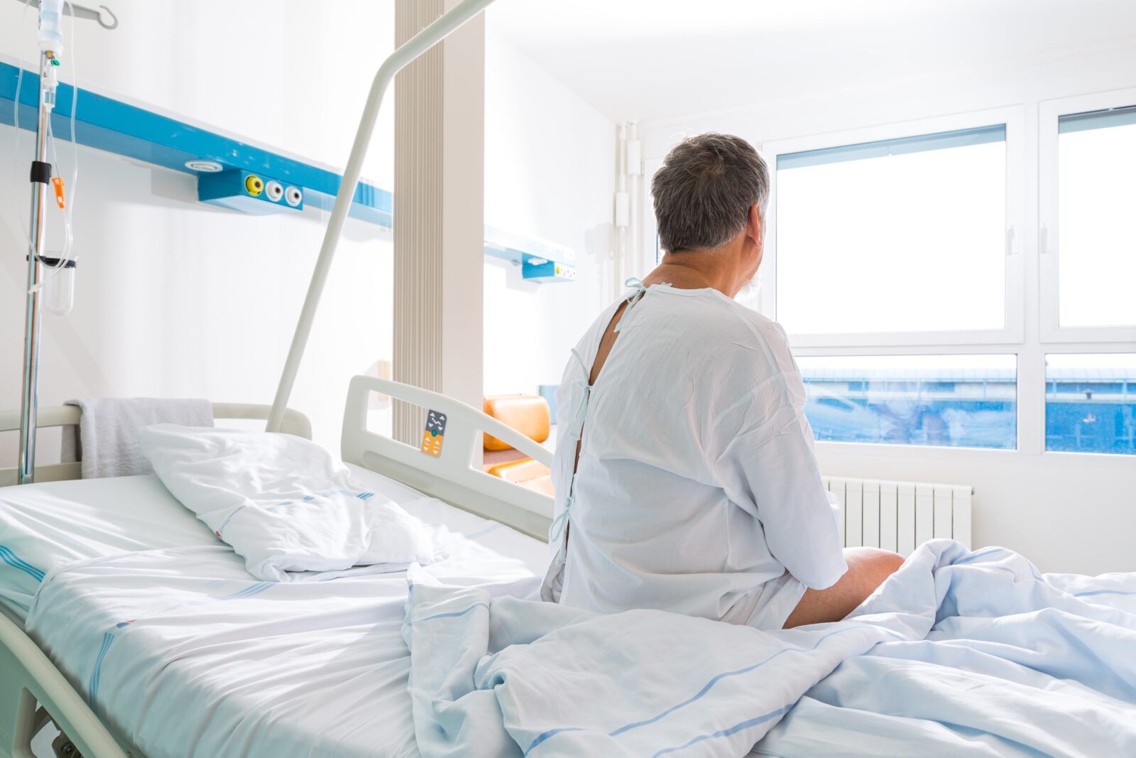 man sitting on hospital bed after surgery