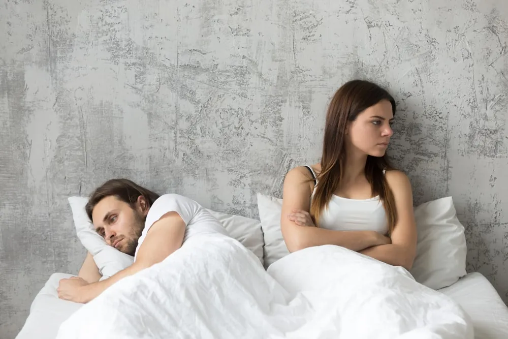 unhappy couple in bed