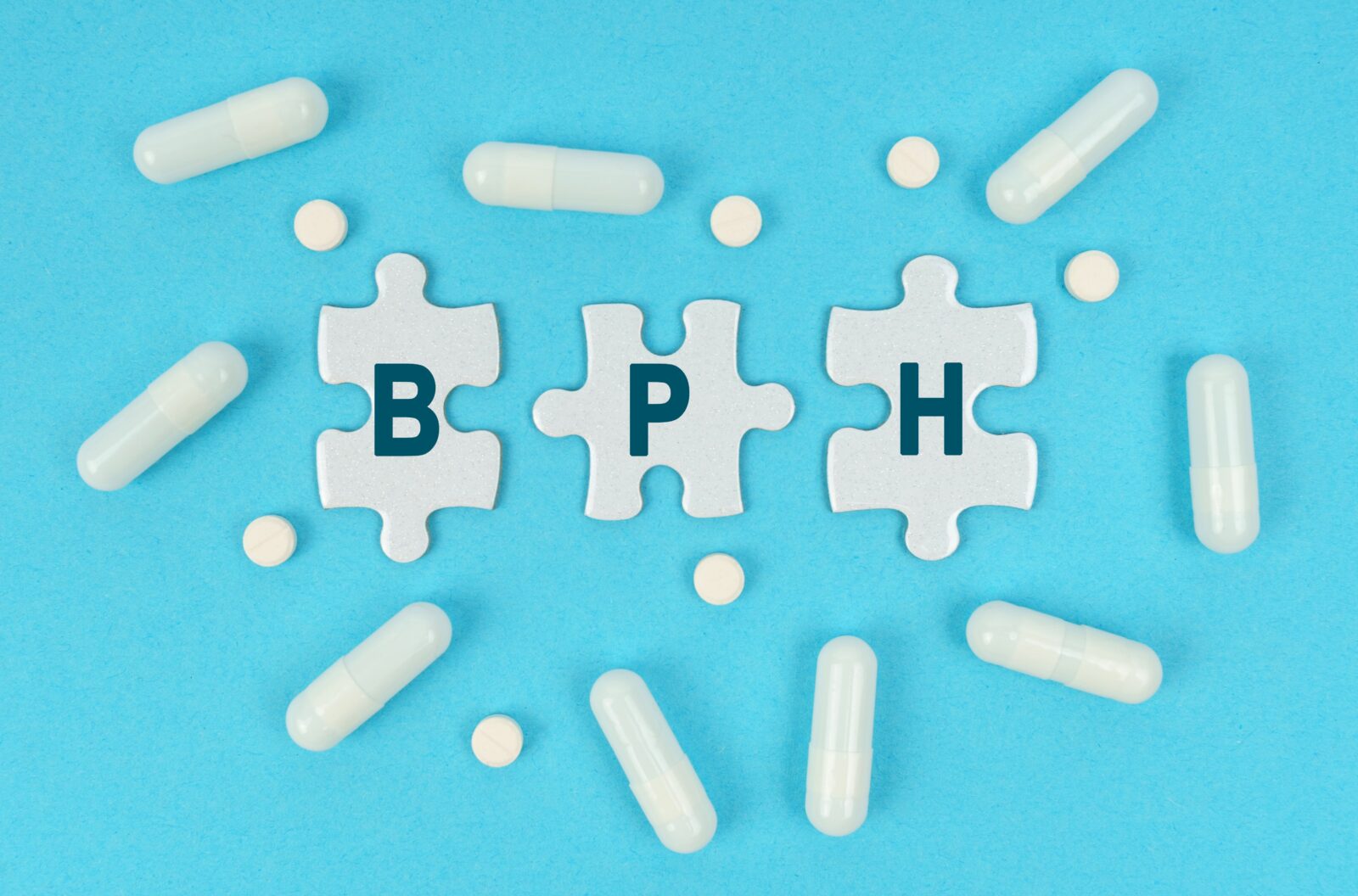 医学与健康。蓝色背景上摆放着药片和拼图,上面写着——BPH